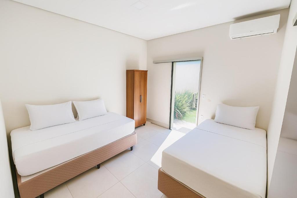 Ένα ή περισσότερα κρεβάτια σε δωμάτιο στο A Casa Paradisíaca ll Luxo Piscina Super Mega Quente até 50 graus Aquecimento Elétrico e Solar Casa com Sauna a Vapor e Ar Condicionado em Todos Ambientes e Lavanderia com Roupa de Cama e Banho