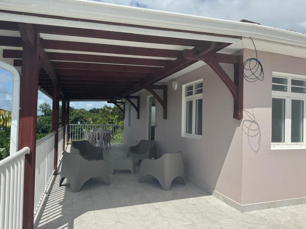 awning over a patio with chairs and a table at Maison Panorama 2 chambres in Sainte-Luce