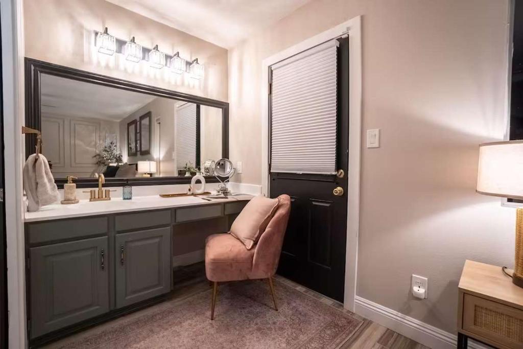 a bathroom with a sink and a mirror and a chair at Cactus Luxury, Comfort, and Amenities galore! in Scottsdale