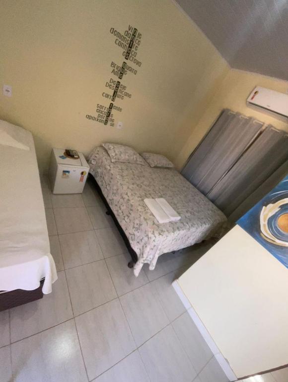 a small bed in a room with a writing on the wall at Pousada Maré do Cerrado in Mateiros