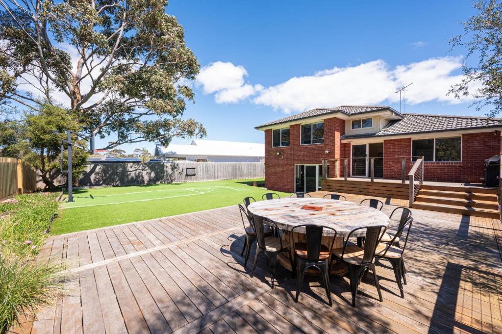 Un patio con una mesa y sillas en una terraza. en Capel Grand Villa - Pet-Friendly Beach Escape, en Rosebud