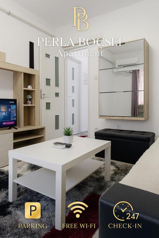 a white living room with a white table and a tv at Perla Bocșei - Apartament Etaj 4 in Bocşa
