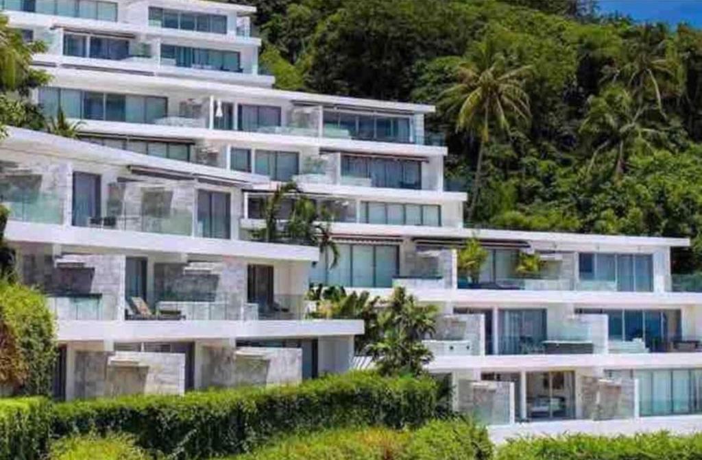 a large white apartment building on a hill with trees at View Phuket Private Pool in Ban Karon