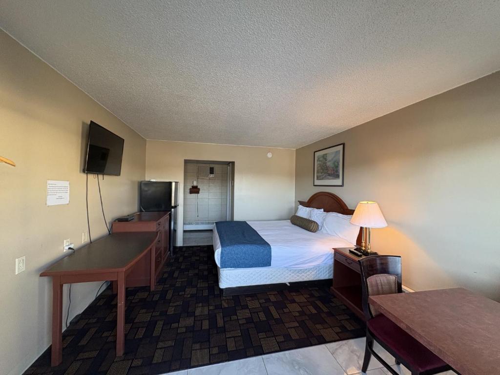Fox CreekにあるAlaskan Motelのベッドとデスクが備わる広い客室です。