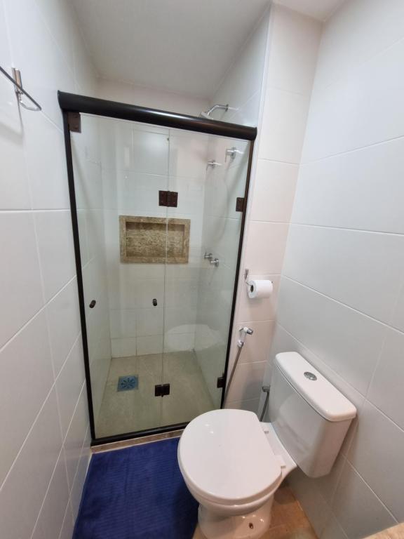 a bathroom with a toilet and a glass shower at Apartamento Frente pra Praia em Resort in Arraial do Cabo