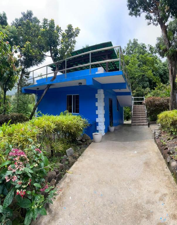 a blue house with a balcony on top of it at Cinnamon Cottage - Peaceful retreat in nature in Soufrière