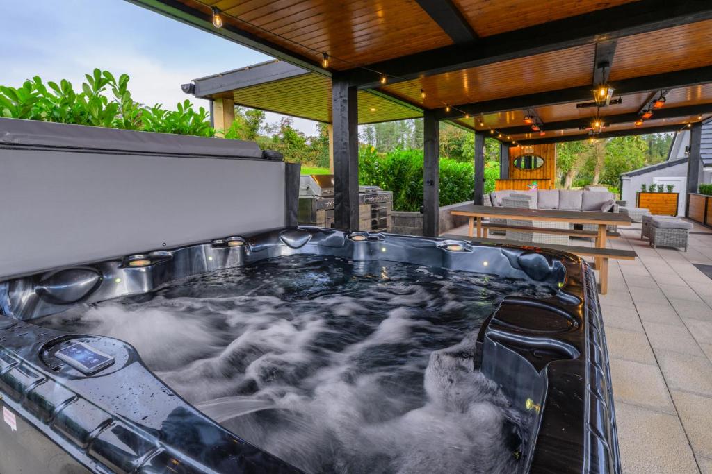 a hot tub on the patio of a house at Rosies Cottage in Rostrevor