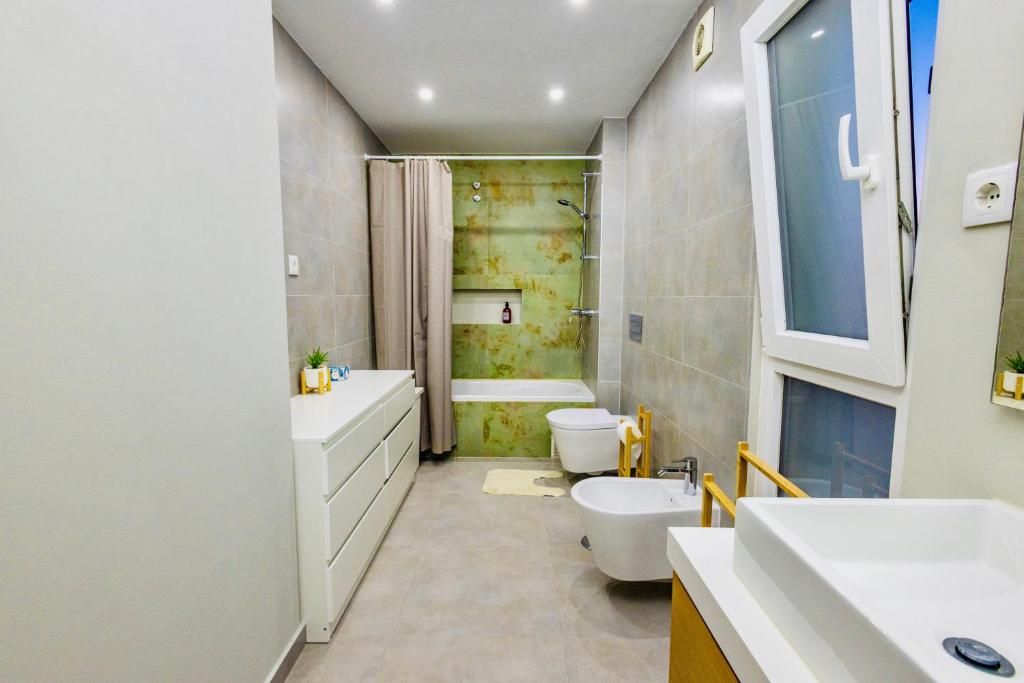 un bagno con lavandino, WC e vasca di JolikaS House Heated Pool and EV point a Fernão Ferro