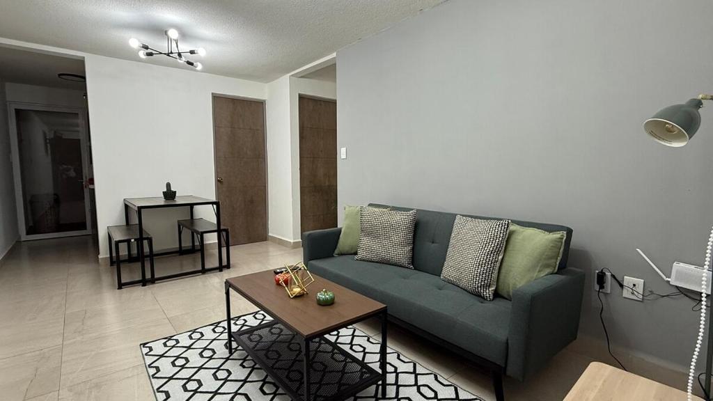 a living room with a blue couch and a table at Dorotea Apartment in San Miguel de Allende