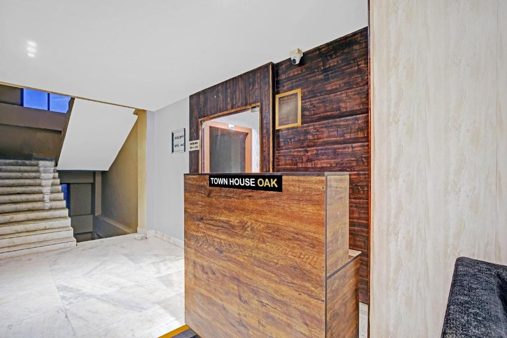 a room with a wooden door with a sign on it at Townhouse OAK Hi-City in Kamakhya