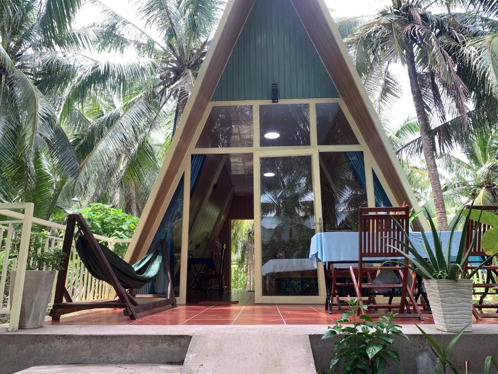 a gazebo with a table and chairs and palm trees at Homestay and Tour Ben Tre in Ben Tre