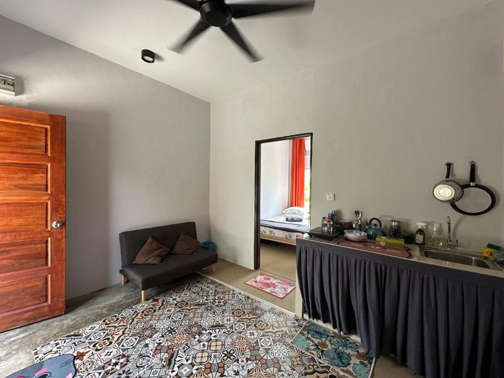 a living room with a couch and a ceiling fan at NazSeri Hideaway in Tanjung Karang