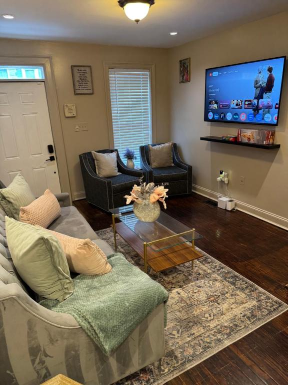 a living room with two couches and a flat screen tv at Townhouse in Baltimore in Baltimore