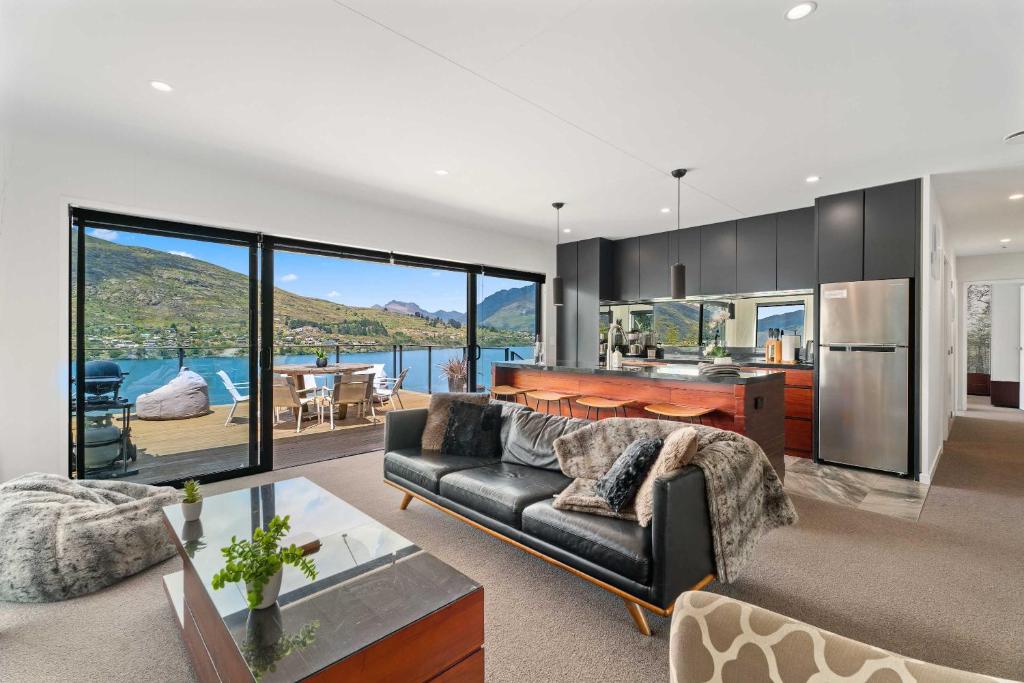 a living room with a couch and a table at Charming Lakeview Home with Remarkable Views in Frankton Wharf