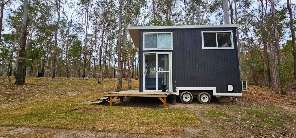 a tiny house sitting on a table in the woods at Hidden Camp's Loft House by Tiny Away in Kanighan