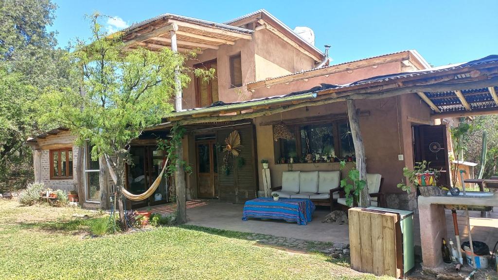 une maison avec un porche avec un canapé blanc dessus dans l'établissement Cabañas Bendita Tierra, à Los Molles