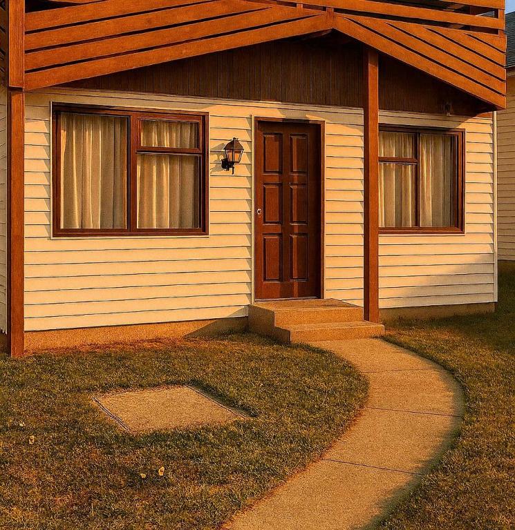 a house with a door and a sidewalk in front of it at Cabañas Puerto Natales centro in Puerto Natales