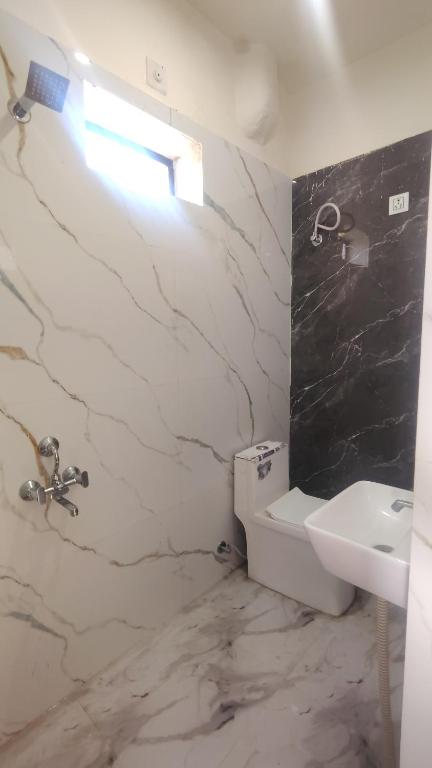 a white bathroom with a sink and a toilet at Hotel kamal hans palace in Udaipur