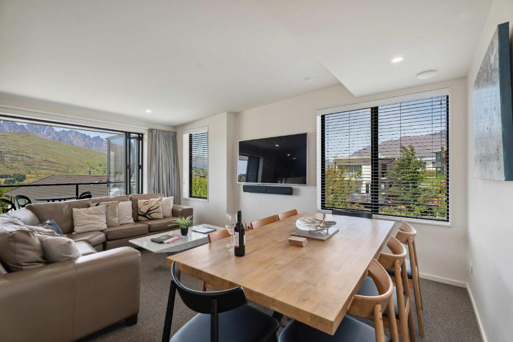 een woonkamer met een tafel en een bank bij Remarkable Lake View in Queenstown