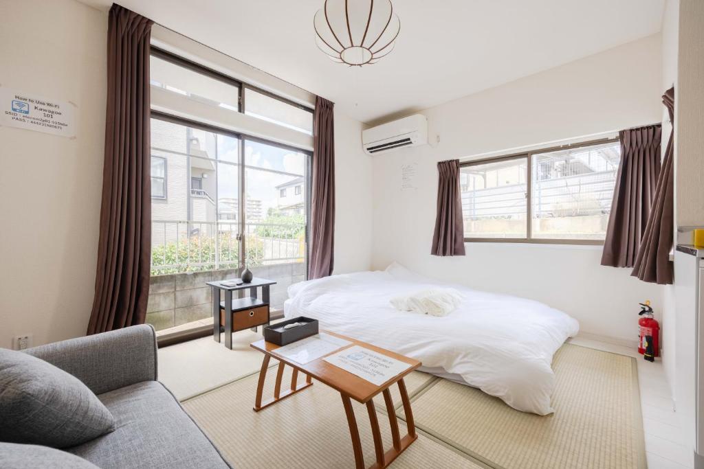 Un dormitorio con una cama y un sofá y una ventana. en Good Place House, en Kawagoe