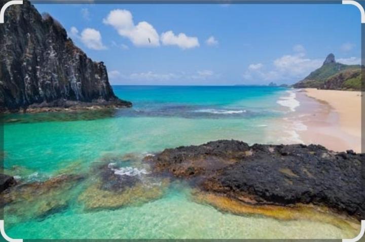a view of a beach with rocks and the ocean at O Paraíso Mar de Vênus in Fernando de Noronha
