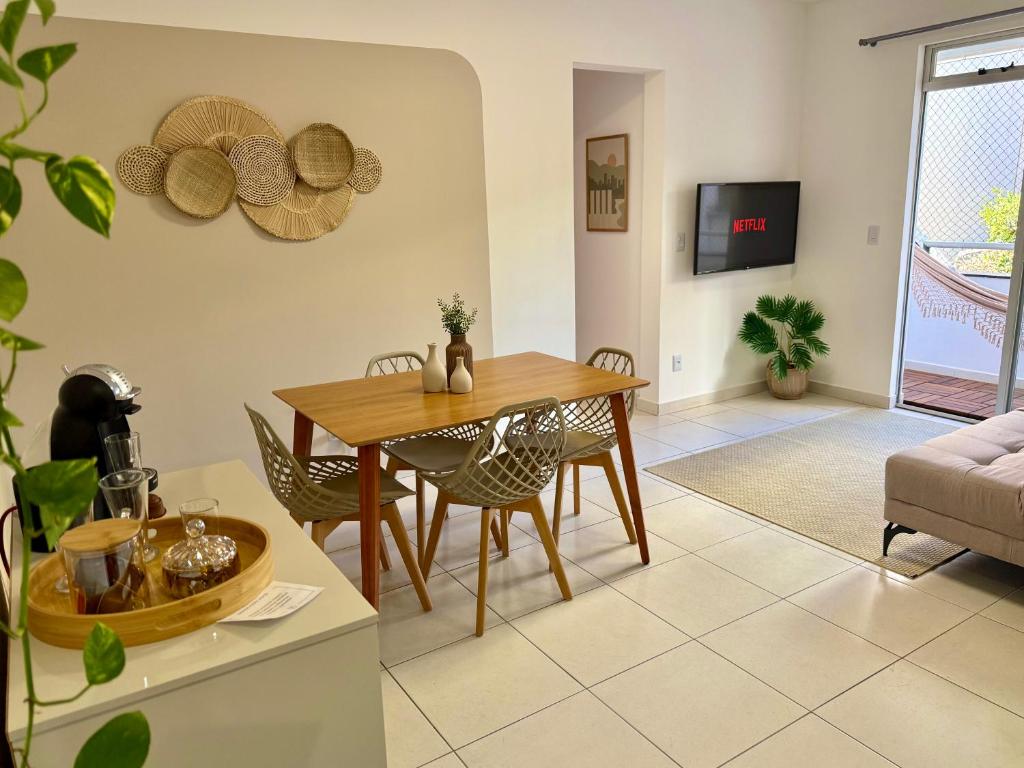 Una sala de estar con una mesa y sillas de madera. en Apartamento em região central com 3 smart TVs - UFV a 1 km, en Viçosa