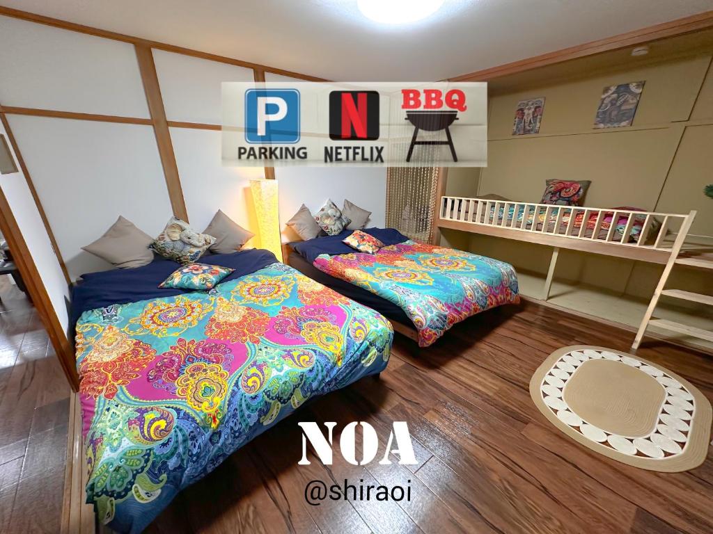 a bedroom with two beds and a crib at Noa in Shiraoi