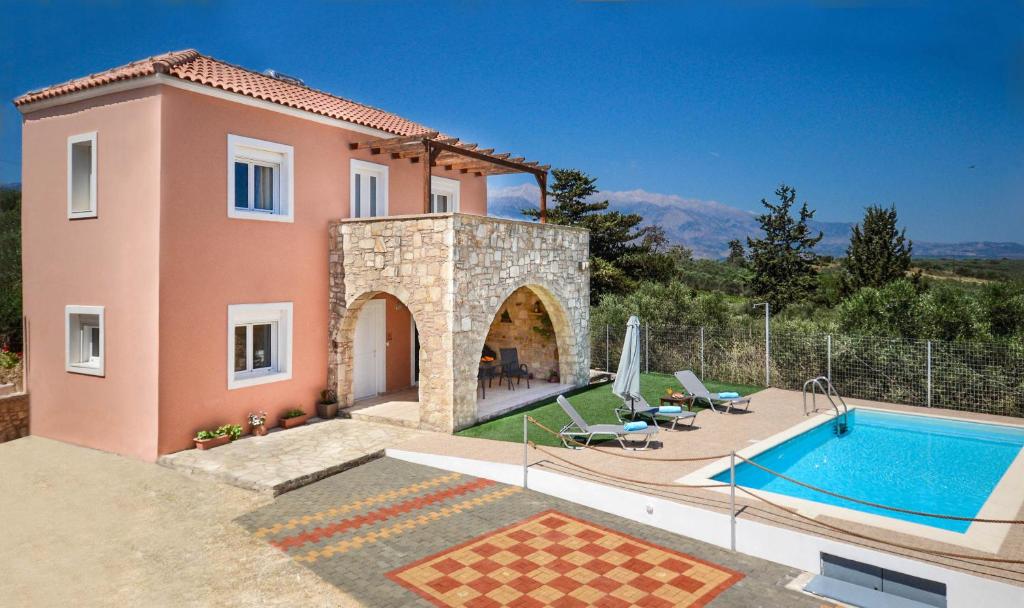 a villa with a swimming pool and a house at Villa Silvia by Andrian Villas in Kalamítsion Alexándrou