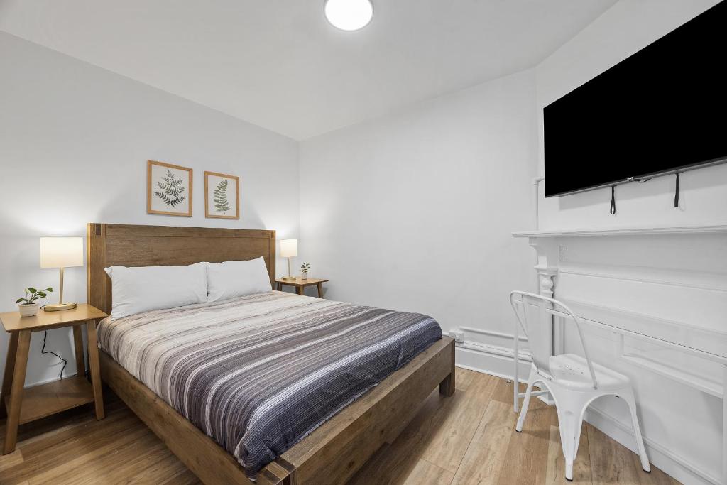 a bedroom with a bed and a flat screen tv at Pittsburgh Shadyside 2B Stylish and Cozy Private Bedroom with Shared Bathroom in Pittsburgh