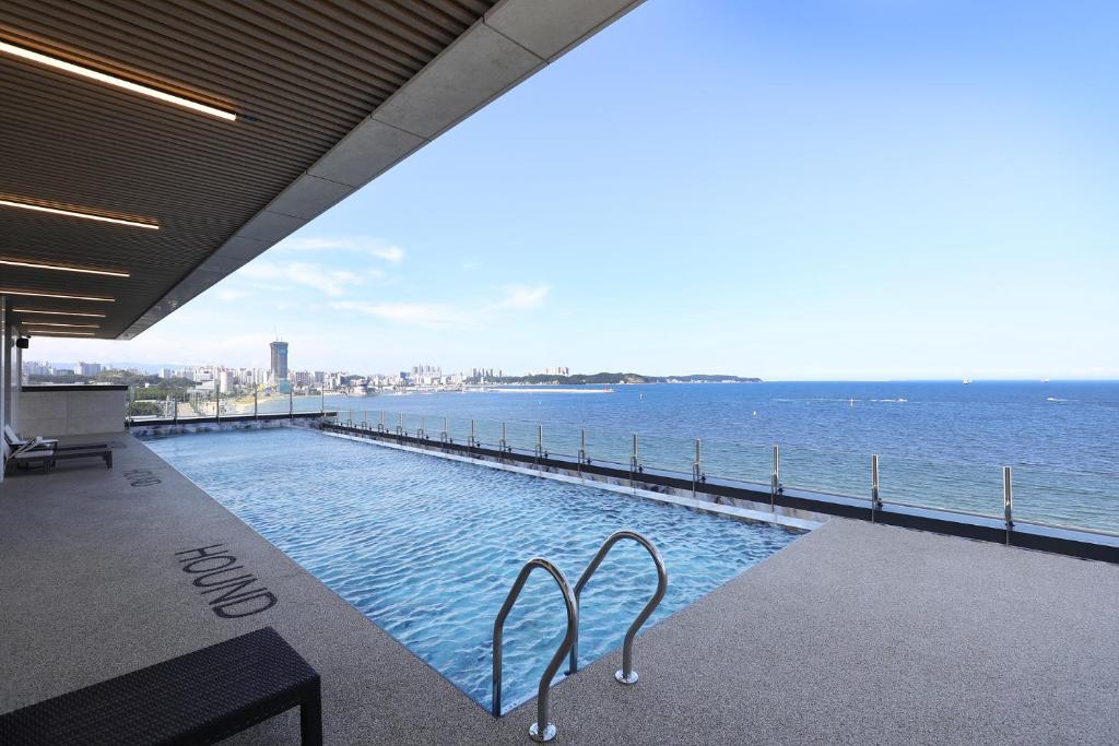 a swimming pool with a view of the water at Pohang Hound Hotel Songdo Beach in Samgong