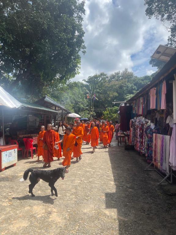 a group of people in orange robes walking through a market at Joeshomestaysiemreap in Phumĭ Bœ̆ng (1)