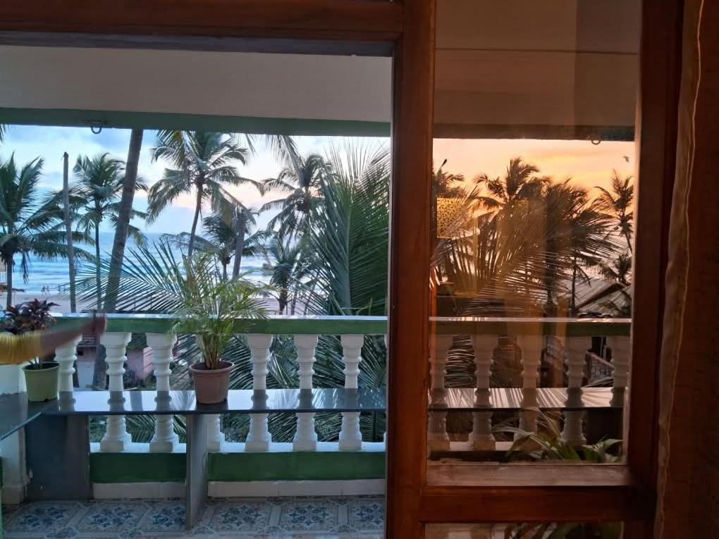 desde un balcón con palmeras y vistas a la playa en Cupid's Heaven Resort, en Agonda