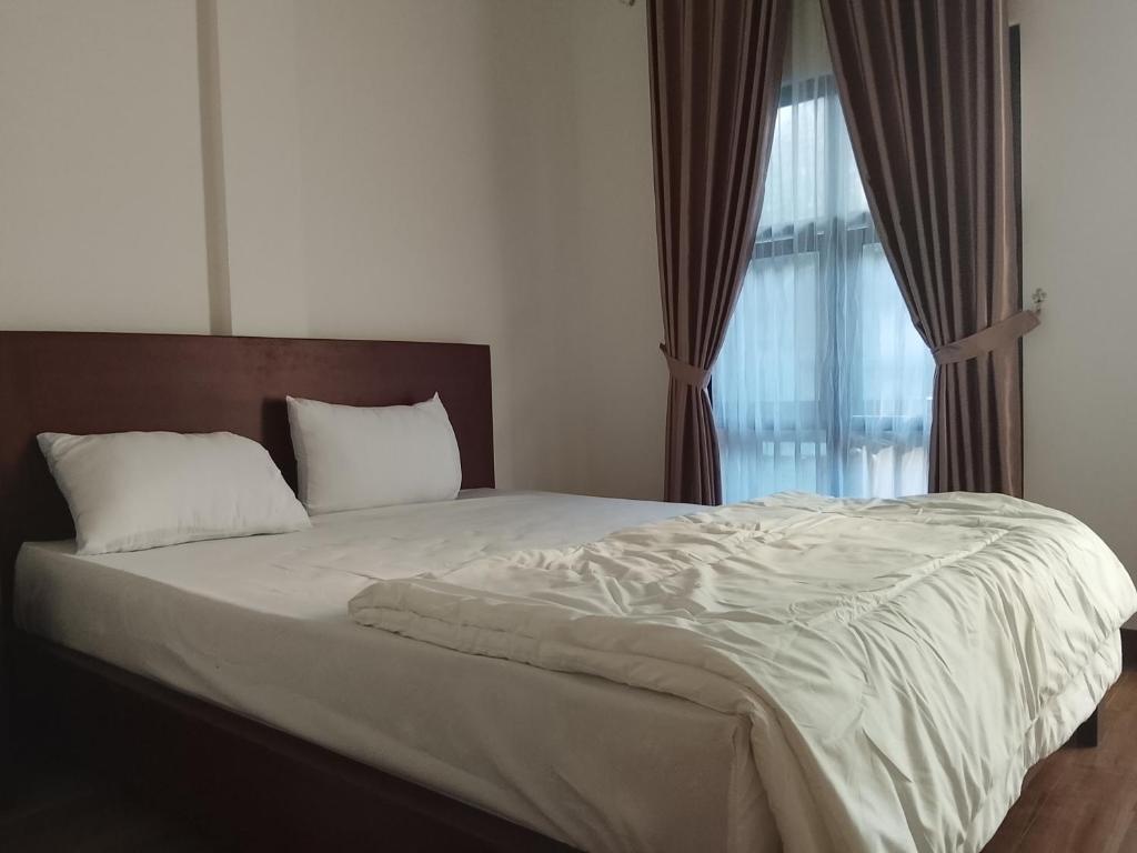 a bedroom with a large bed with a window at Pandava House Lombok in Lombok International Airport