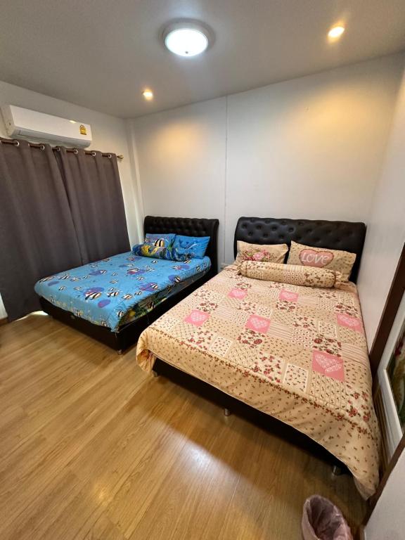 a bedroom with two beds and a futon at NB bangsaen house KL2 in Ban Puk (2)