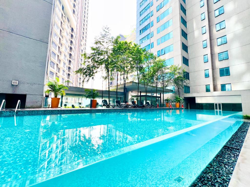 a swimming pool in a building with tall buildings at Luxury Summer Suites KLCC By LEXA Stay in Kuala Lumpur