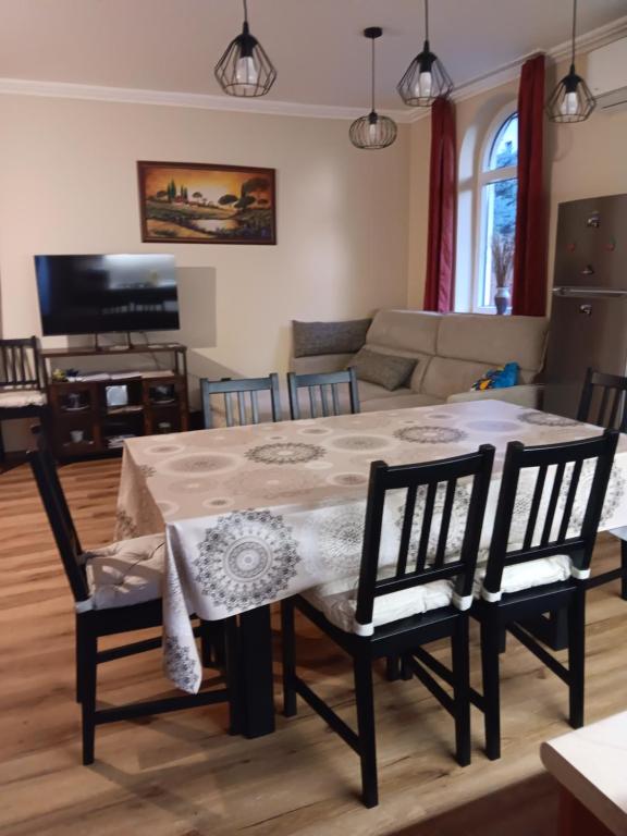 a living room with a dining room table and chairs at Mazsola Vendégház in Tamási