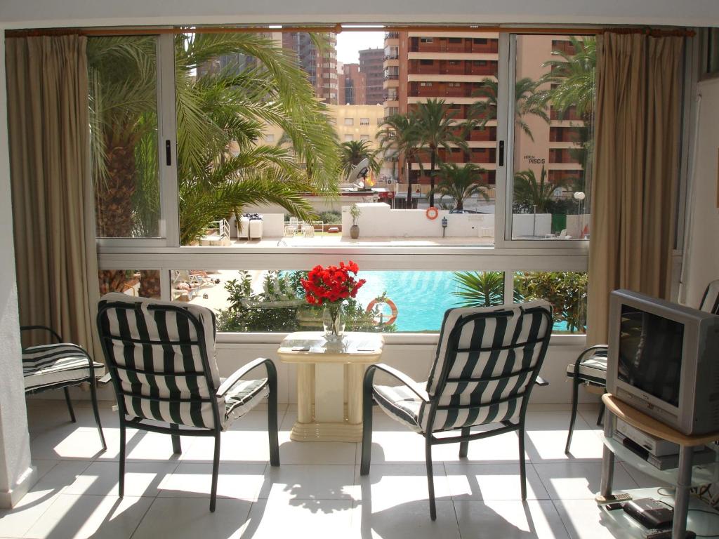 ベニドルムにあるVersalles - Zand Propertiesの椅子2脚、テーブル、窓が備わる客室です。