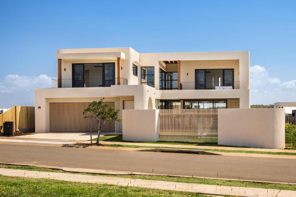 a white house with a fence in front of it at Wave Break in North Creek