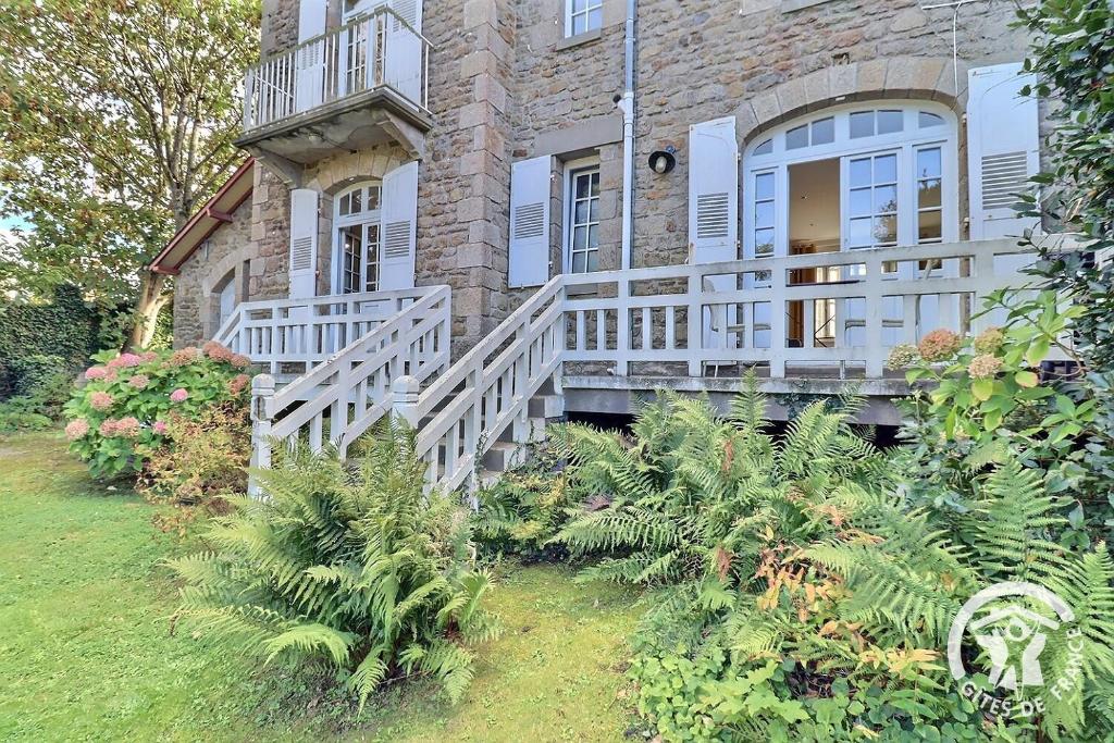 una casa in mattoni con portico con ringhiera bianca di Le safran a Dinard