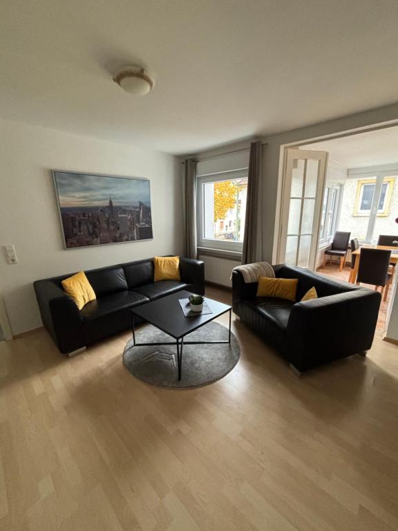 a living room with a black couch and a table at Apartment in Osnabrück in Osnabrück