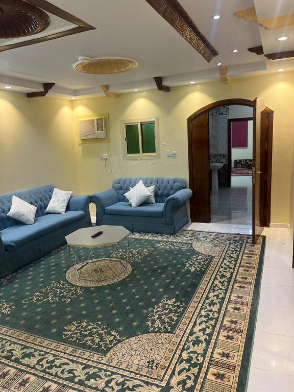 a living room with a blue couch and a rug at شقق لافندر in Sūq ath Thalut