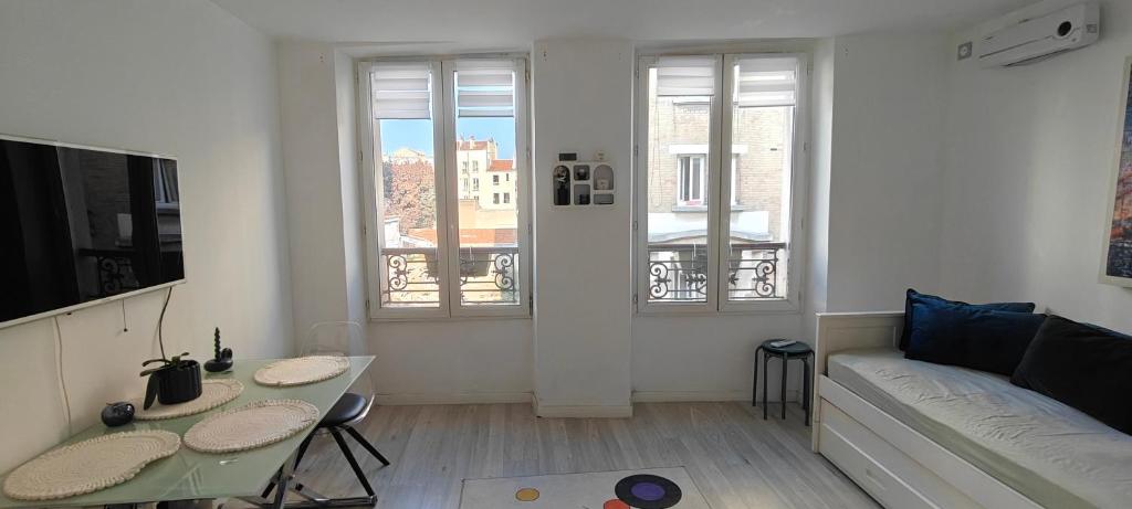 una sala de estar con un sofá y una mesa en Appartement paisible, en Clichy