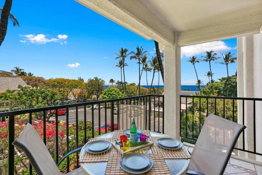 a table on a balcony with a view of the ocean at Kihei Akahi C302 · AKH C302 Spacious 2BD Condo w Ocean Breeze AC in Wailea