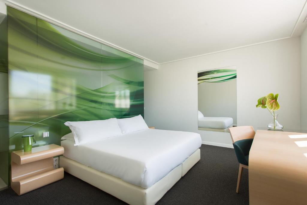 a bedroom with a white bed and a desk at Room Mate Oscar, Madrid in Madrid