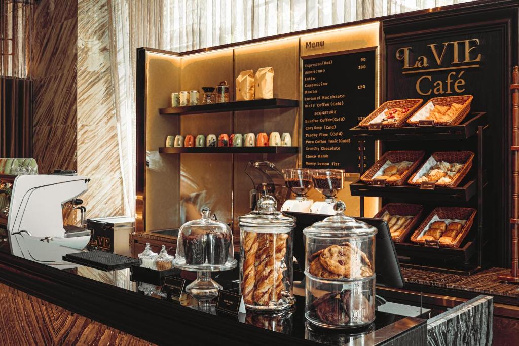 A café counter displaying pastries, coffee equipment and a printed menu.