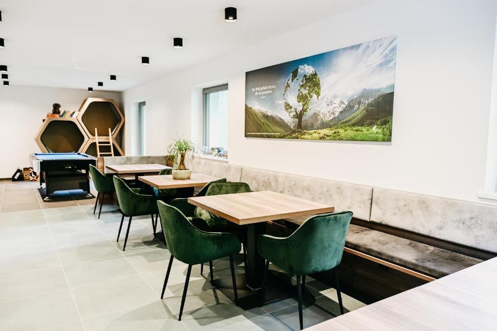un restaurante con mesas y sillas y una pintura en la pared en nature house, en Colle Isarco