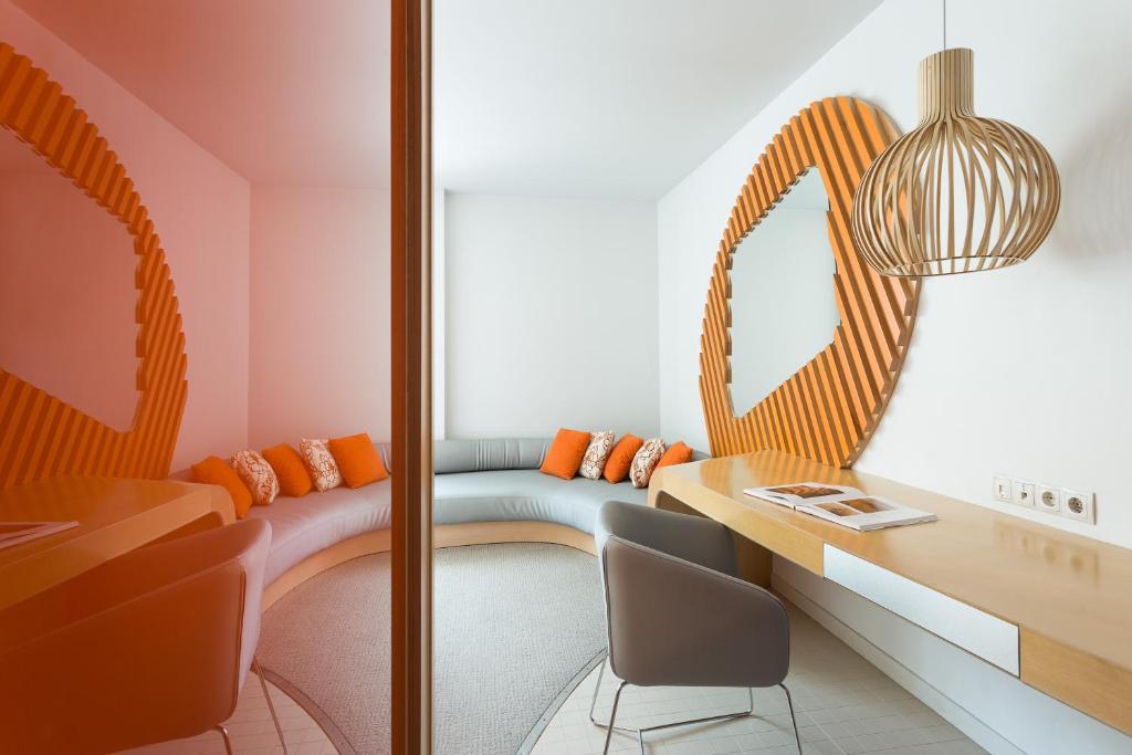 a room with a bench and a table and chairs at Room Mate Oscar, Madrid in Madrid