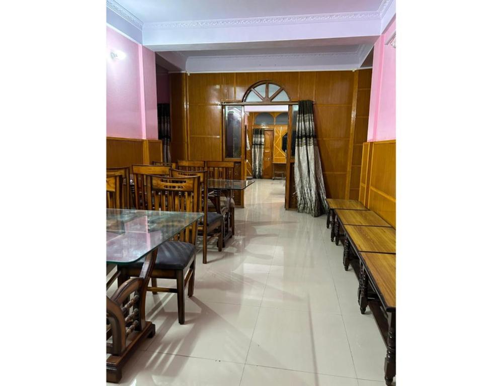 a restaurant with wooden tables and chairs and a hallway at HotelSonamTawang in Tawang