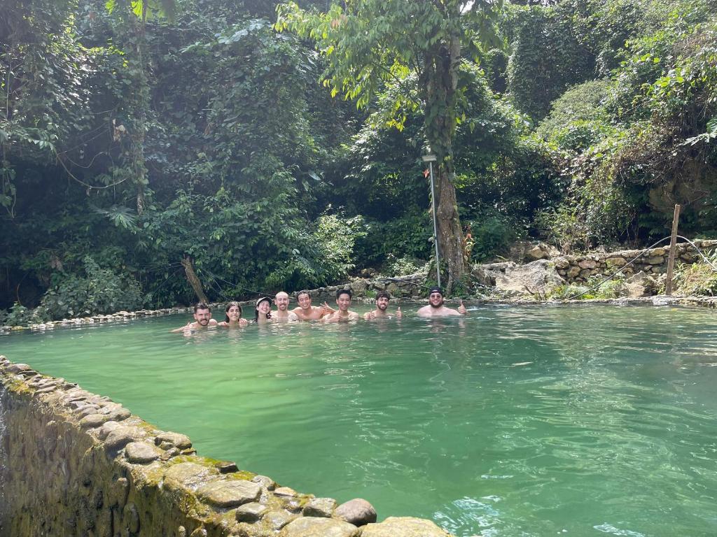 a group of people swimming in a pool of water at Mai Chau Hostel in Mai Chau