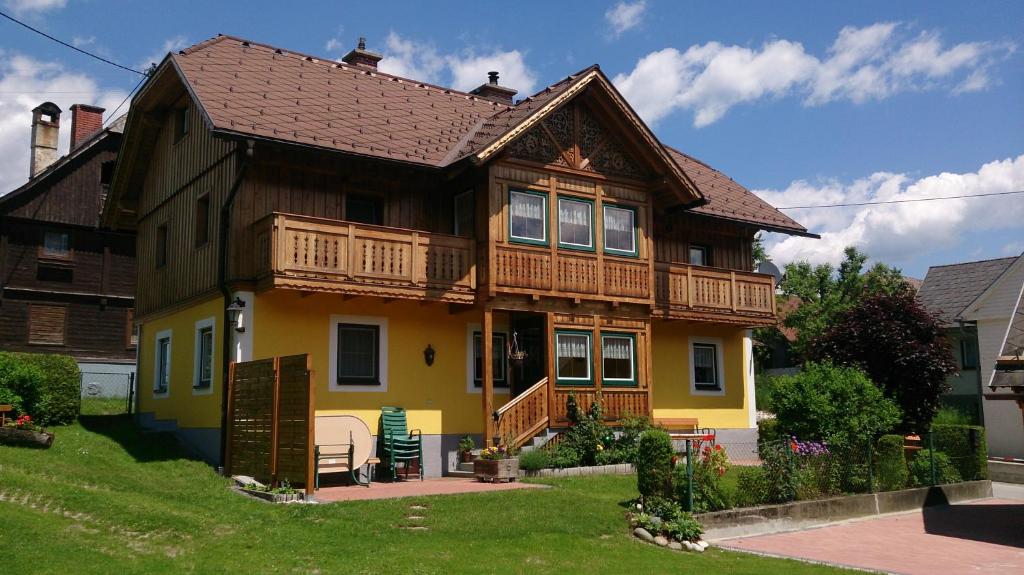 une maison jaune avec un toit en bois dans l'établissement Landhaus Tippl, à Aigen im Ennstal